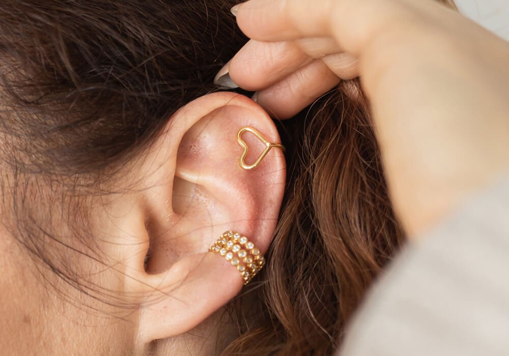 Woman wearing a gold earring from a jewelry store in Cape Coral