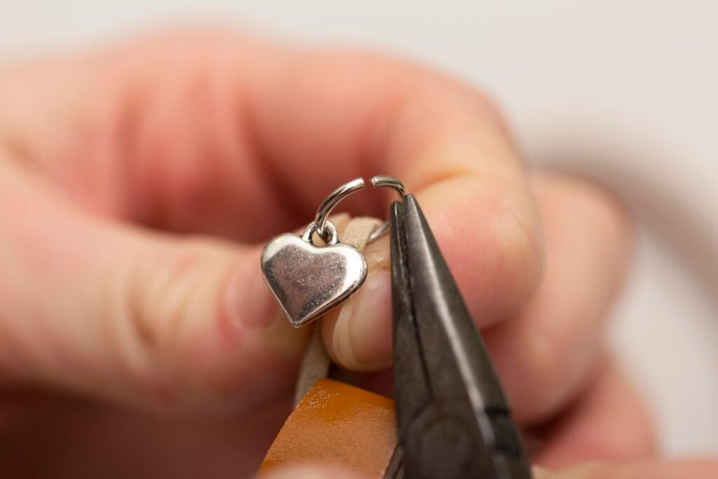 Jewelry repair in Cape Coral showing a small metallic heart being carefully restored